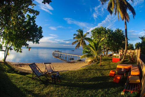 a beach with two lounge chairs and a dock at Chez Nath in Sainte Marie