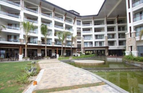 a large apartment building with a pond in front of it at The Bellevue Resort in Panglao