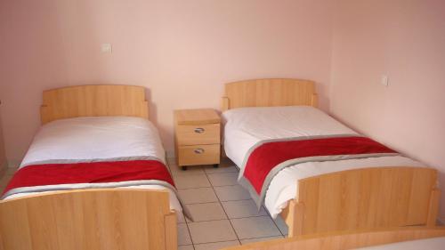 LanarceにあるAuberge De Peyrebeilleのベッド2台が隣同士に設置された部屋です。