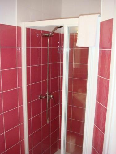 ein Bad mit einer Dusche mit roten Fliesen in der Unterkunft Auberge De Peyrebeille in Lanarce