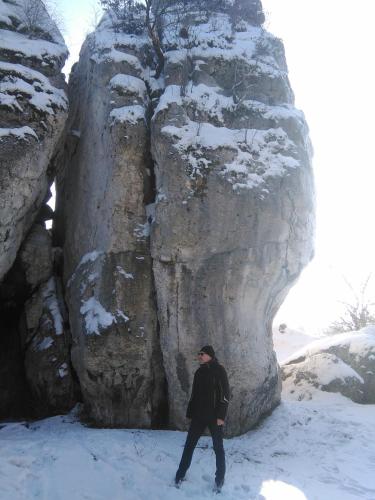 a man walking in the snow in front of a rock formation at Jurajska Bajka in Przybynów