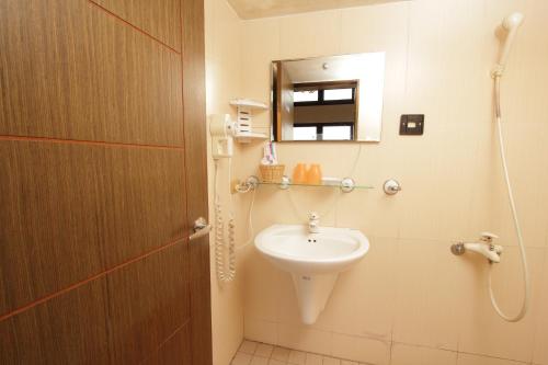 Sanyi Sakura Resort في ساني: حمام مع حوض ومرآة