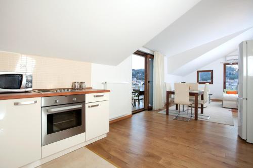 a kitchen with white appliances and a dining room at Apartments Tisno - Villa Mare in Tisno