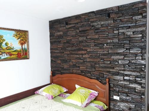 a bedroom with a brick wall and a bed at Casa Papava in Băile Herculane