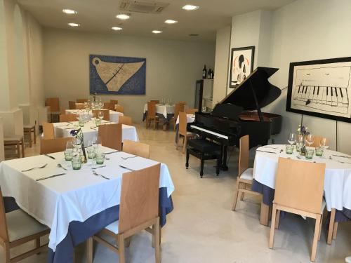 a dining room with white tables and a piano at La Merced de la Concordia in Tarazona de Aragón
