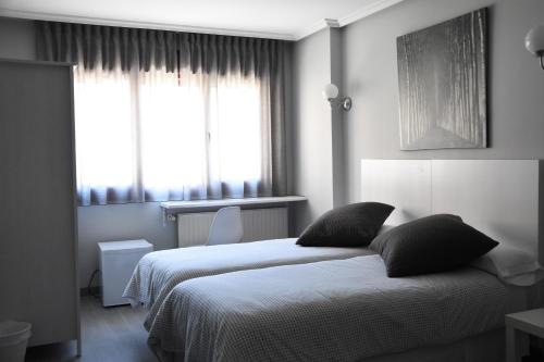 ein Hotelzimmer mit 2 Betten und einem Fenster in der Unterkunft Hotel Carbayon in Oviedo
