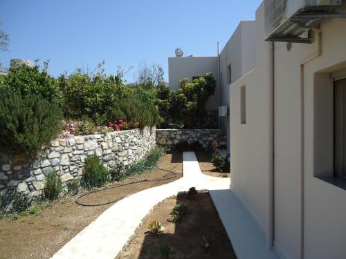 a stone wall next to a white building at Mythos Suites Diskos in Léntas