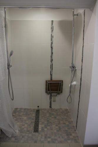 a bathroom with a shower and a tile floor at Le Clos du Square - climatisé in Rochefort