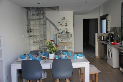 a white table with blue chairs in a kitchen at Le Clos du Square - climatisé in Rochefort