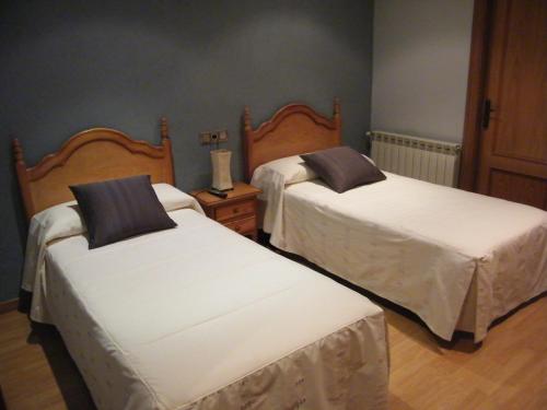 a bedroom with two beds with white sheets at El Pedrís in El Pont de Suert