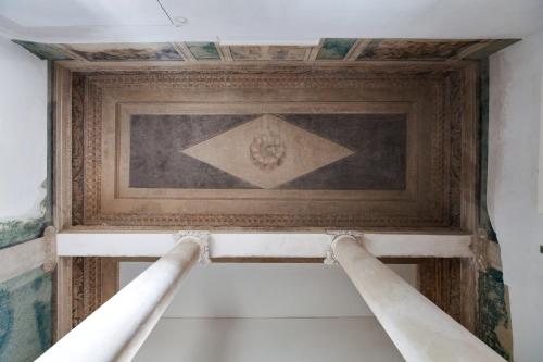 a painting on the ceiling of a room with columns at Hotel Pacai, Vilnius, a Member of Design Hotels in Vilnius