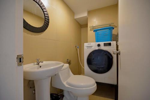 y baño con lavamanos y lavadora. en Victoria SOHO Suites, en Manila