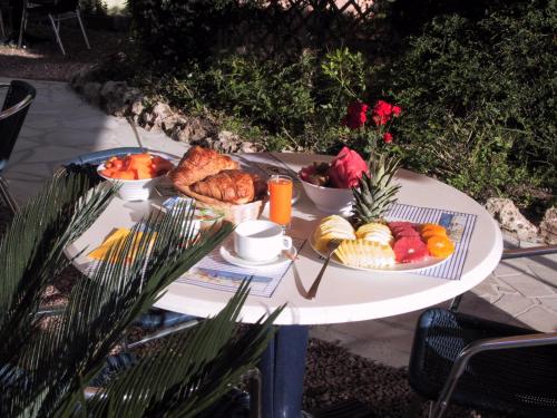 a table with a tray of breakfast foods on it at Logis Hotel l'Esterella in Agay - Saint Raphael