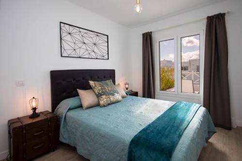 a bedroom with a large bed and a window at Flower Beach Lanzarote in Playa Honda