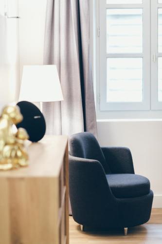 a blue chair sitting next to a table with a lamp at T3 luxe hyper centre in Bordeaux