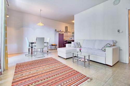 a living room with a white couch and a table at SUMMERTIME house with apartment in Umag