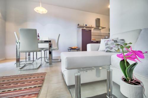 a living room with a white couch and a table at SUMMERTIME house with apartment in Umag
