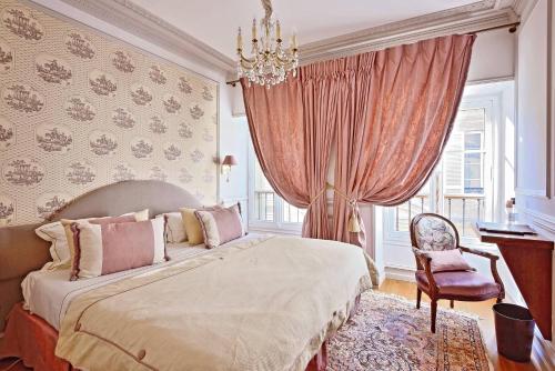 - une chambre avec un grand lit et une chaise dans l'établissement Villa Victor Louis - Bordeaux Centre, à Bordeaux