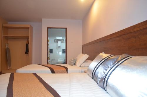 a hotel room with two beds and a mirror at TD Mutiara Hotel Semporna in Semporna