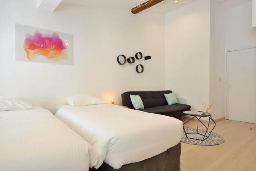 une chambre avec deux lits et une chaise dans l'établissement Studio Elly, à Cannes