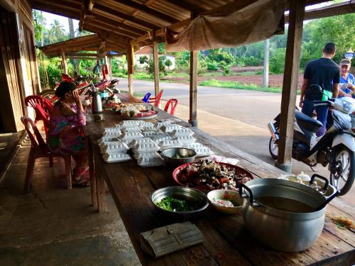 ein langer Holztisch mit Essen darüber in der Unterkunft Gardenhomeresortkohjum in Ko Jum