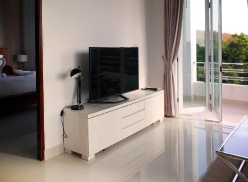 a living room with a television on a white dresser at Lanta Sport Resort in Ko Lanta
