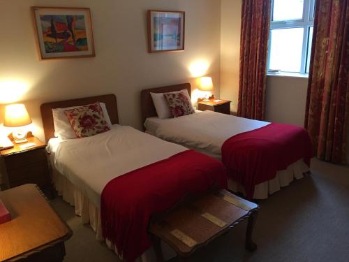 a hotel room with two beds and a window at O'Donovan's Hotel in Clonakilty