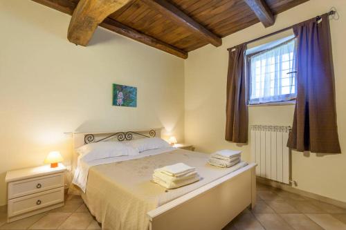 ein Schlafzimmer mit einem großen Bett und einem Fenster in der Unterkunft Ciards House in Montefalco