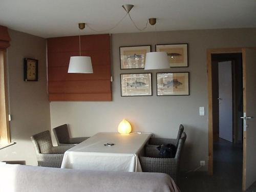 een eetkamer met een witte tafel en stoelen bij Zonnig appartement in Nieuwpoort