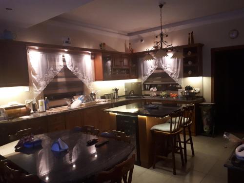 uma cozinha com armários de madeira e uma mesa com cadeiras em Nocturne Family House em Paola