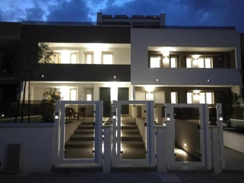 a white building with doors and stairs at night at Manolo Case Vacanza in Monopoli