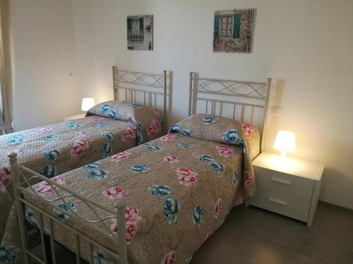 a bedroom with two beds and a table with a lamp at Manolo Case Vacanza in Monopoli