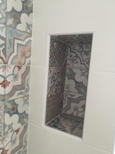 a mirror in a bathroom with a patterned wall at Manolo Case Vacanza in Monopoli