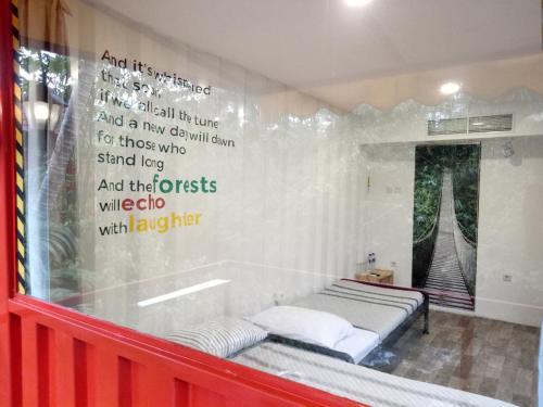 a bedroom with a bed and writing on the wall at Hau Eco Lodges Citumang Pangandaran in Pangandaran