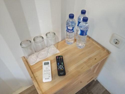 a table with two bottles and glasses and a remote control at Hau Eco Lodges Citumang Pangandaran in Pangandaran