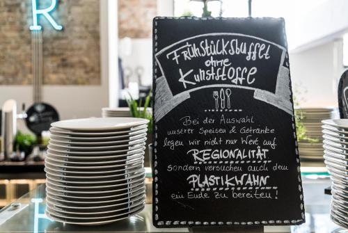 a sign for a table with plates on a table at Hotel Oderberger in Berlin