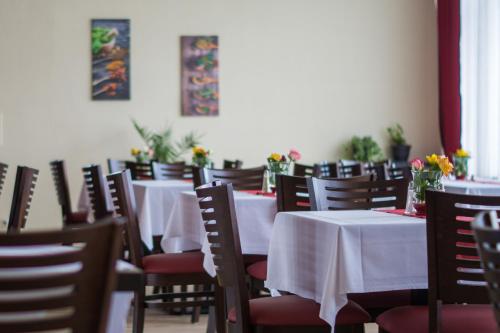 uma sala de jantar com mesas e cadeiras com flores em "Anderer´s" Gasthaus & Hotel Hohne em Hohne