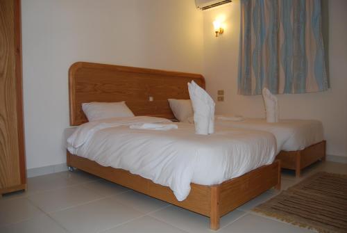 a bedroom with two beds with white sheets at Acacia Dahab Hotel in Dahab