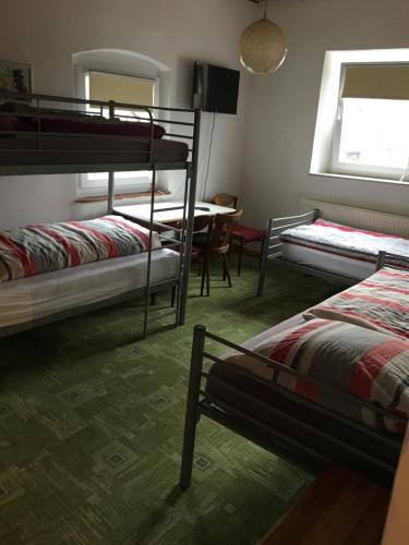 Zimmer mit 3 Etagenbetten und einem Tisch in der Unterkunft Zur Krone in Wolfsegg