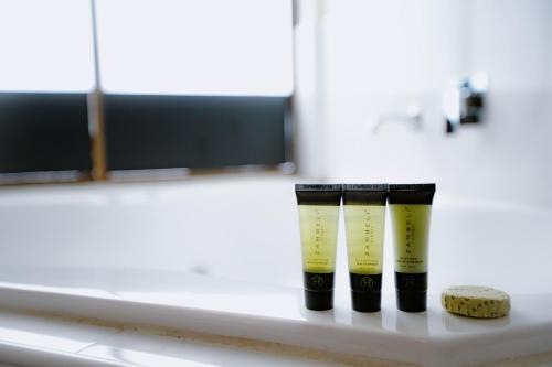 a row of four yellow candles on a shelf at Garden Lodge Sydney Hotel in Sydney