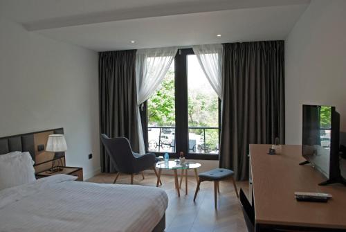 a hotel room with a bed and a desk and a tv at Prime Hotel in Tirana