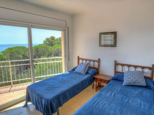 um quarto com 2 camas e uma varanda em D27032 caoca em Sant Feliu de Guíxols