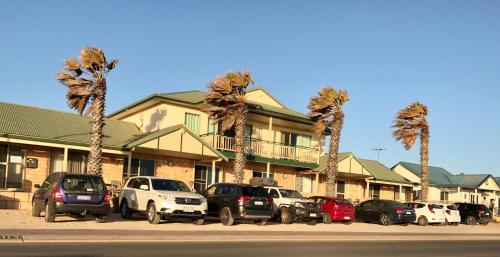 eine Gruppe von Autos, die vor einem Gebäude geparkt sind in der Unterkunft Bay Lodge in Denham