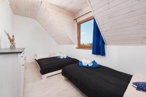 two beds in a room with a window at Domki Marco Polo in Władysławowo