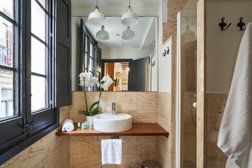 een badkamer met een wastafel en een spiegel bij AinB Gothic-Jaume I Apartments in Barcelona