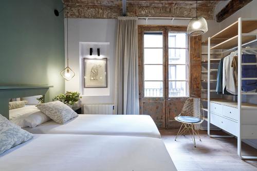 1 dormitorio con 2 camas y ventana en AinB Gothic-Jaume I Apartments, en Barcelona