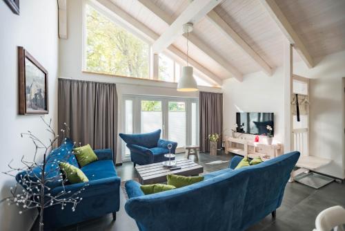 a living room with blue furniture and a large window at Waldsiedlung in Kröpelin