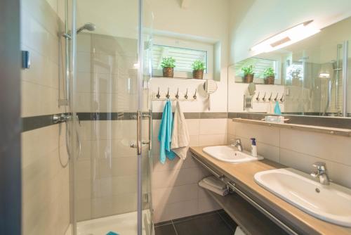 W łazience znajdują się 2 umywalki i przeszklony prysznic. w obiekcie Waldsiedlung w mieście Kröpelin