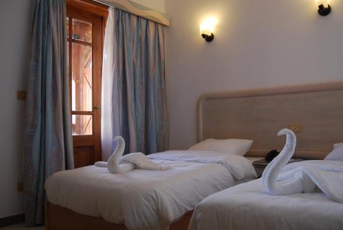 two swans sitting on two beds in a room at Acacia Dahab Hotel in Dahab