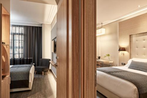 a hotel room with a bed and a desk at Antigon Urban Chic Hotel, Thessaloniki in Thessaloniki